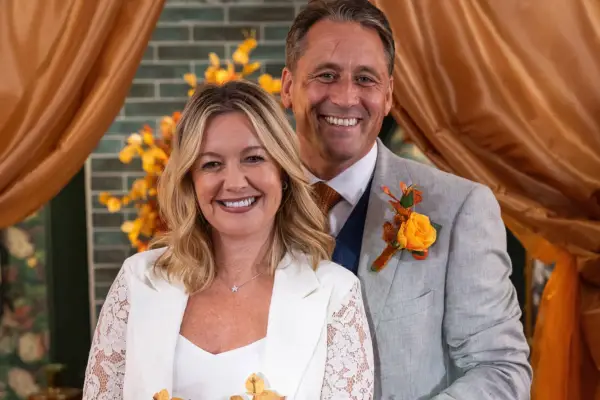 Diane and Tony dressed in wedding outfits and smiling in Hollyoaks