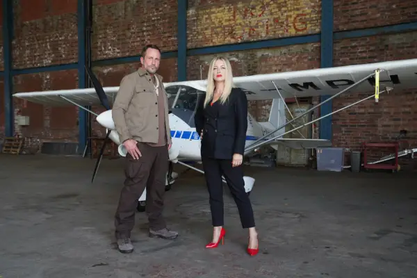 Jez and Clare standing in front of a plane in Hollyoaks