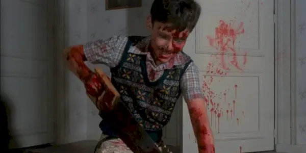 Boy murdering someone with a chainsaw in Pieces movie