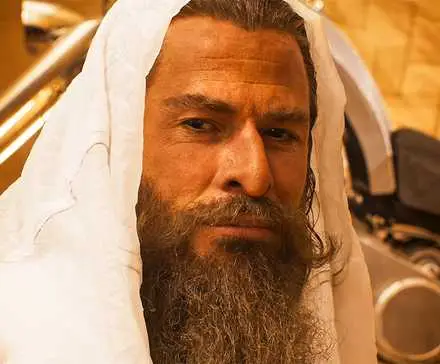 Dementus played by Chris Hemsworth in a white hood in Furiosa: A Mad Max Saga