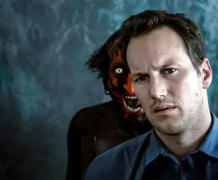 Josh is sitting at the kitchen table with the Lipstick-Face Demon popping up behind him in Insidious.