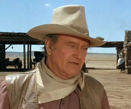 John Wayne as Wil Andersen on his ranch, looking at a person offscreen in 