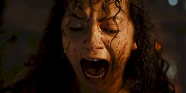 Close-up of a bloody Isabela Merced as Kay screaming and looking down in Alien: Romulus