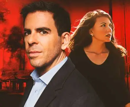 Director Eli Roth stands in front of actor Cerina Vincent as Marcy, with the poster for Cabin Fever in the background.