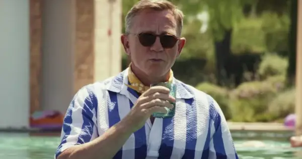 Daniel Craig as Benoit Blanc Holding a Drink in the pool in Glass Onion
