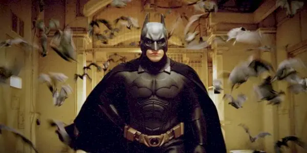 Batman running down a hallway surrounded by bats in Batman Begins