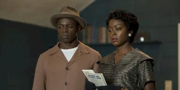 Mamie and Gene standing side by side and looking in the same direction in Till.