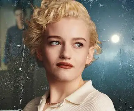 Actress Julia Garner standing in front of a murky background of a full moon and an office.