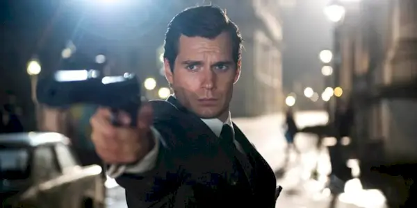 Napoleon Solo stands in a European street at night & aims his pistol in Man From UNCLE