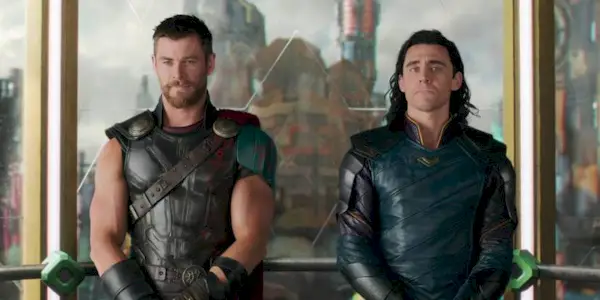 Tom Hiddleston and Chris Hemsworth as Thor and Loki standing by each other
