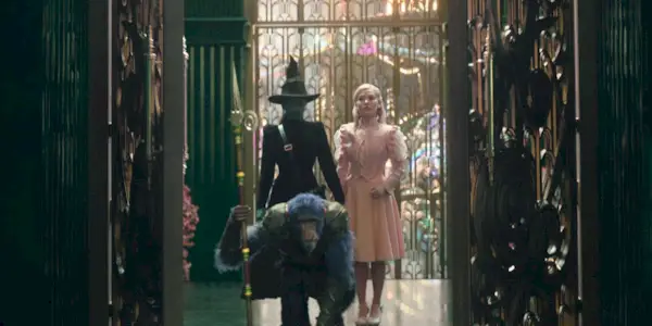 Elphaba (Cynthia Erivo) and Glinda (Ariana Grande) are led in by a monkey guard in 