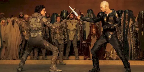 Paul Atreides and Feyd-Rautha face off with knives while a crowd watches on in 
