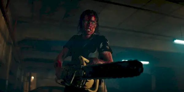 Lily Sullivan as Beth, covered in blood and wielding a chainsaw in Evil Dead Rise