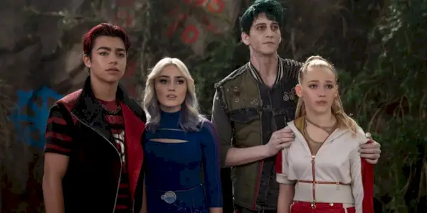 Victor, Addison, Zed and Nova, played by actors Malachi Barton, Meg Donnelly, Milo Manheim and Freya Skye, stand in a row looking at something off-screen in Zombies 4: Dawn of the Vampires.