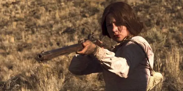 Emily Theterow pointing a gun at something off-camera in Meek