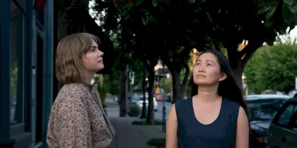 Lizzy and Jo looking up while standing on the street in the movie Showing Up.