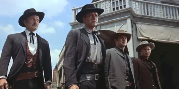 Kirk Douglas, Burt Lancaster, DeForest Kelley and John Hudson standing next to each other in a straight line in Gunfight at the OK Corral