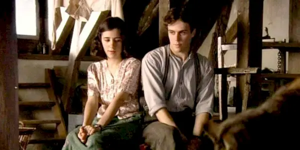 Ellie Kendrick and Geoffrey Breton as Anne and Peter sitting together in the annexed attic in 