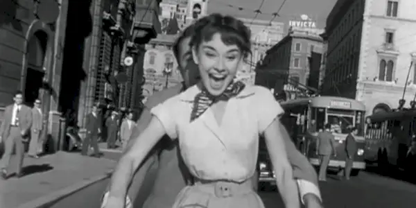 Princess Anne riding a vespa and laughing in Roman Holiday.