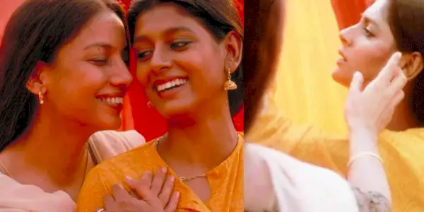 Fire two indian women gaze lovingly at each other, one touches the others cheek