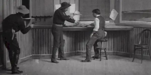 Two outlaws aiming guns at a man in The-Great-Train-Robbery