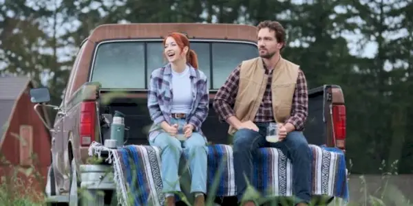 Emily Tennant and Jake Foy sitting in the back of a pickup truck in 