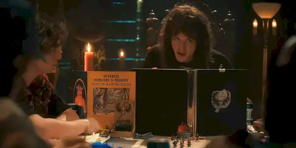 Eddie acts as Dungeon Master behind his D&D book around a table of the main cast in Stranger Things.