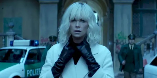 An MI6 operative dons a disguise, readying herself for combat with two German police officers. 