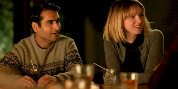 Kumail and Emily at dinner looking to their left in The Big Sick