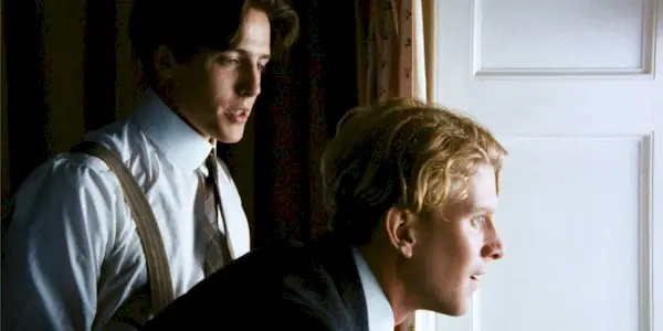 Actors Hugh Grant and James Wilby as Clive and Maurice, looking out a window in Maurice