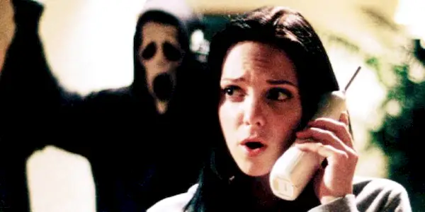 Cindy (Anna Faris) on the phone while Ghostface stands behind her in Scary Movie