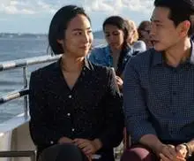 A man and a woman (Greta Lee and Teo Yoo) talking aboard a ship in the film Past Lives.