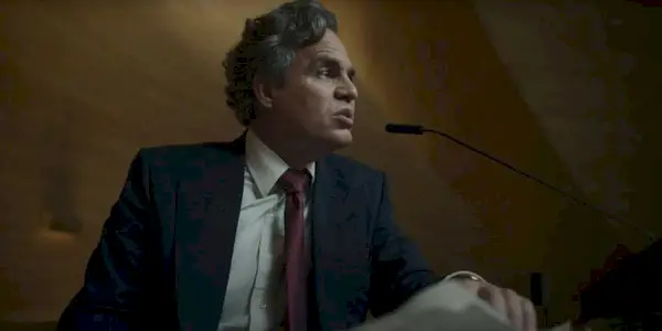 Mark Ruffalo as Hieronymous Marshall speaking at a podium in Mickey 17.