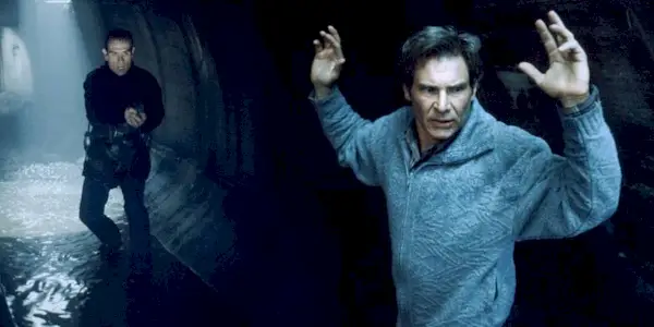 Harrison Ford raising his hands while Tommy Lee Jones approaches him in The Fugitive