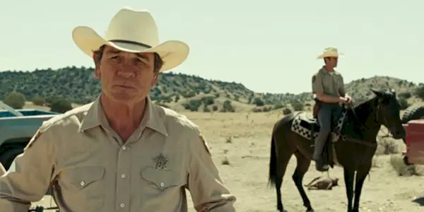 Sheriff Bell (Tommy Lee Jones) standing in a desert near an officer in 