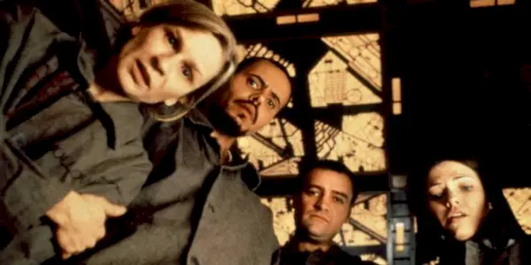 Nicole de Boer, Nicky Guadagni, David Hewlett, & Maurice Dean Wint looking down at an object in Cube 