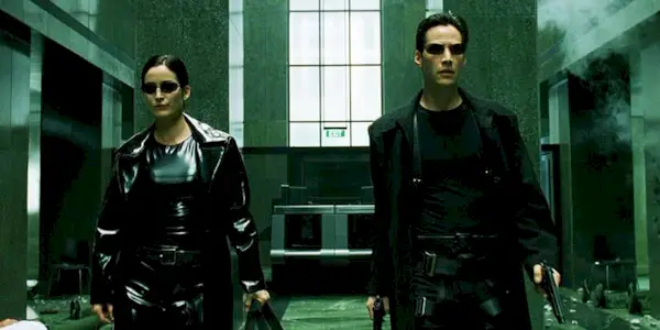 Trinity and Neo walking down an empty room in The Matrix.