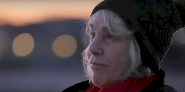 Cathy Terkanian wears a black beanie and a red scarf as she looks for her daughter