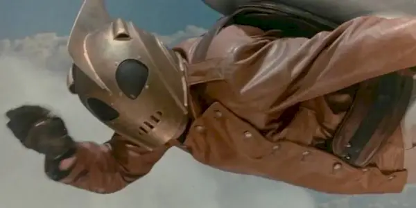 A superhero soars through the sky with his jetpack.