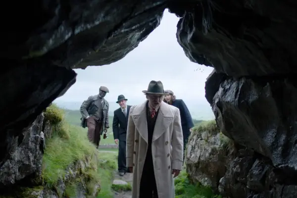 Simon Pegg in Nandor Fodor looking into a cave, with people stood in the background