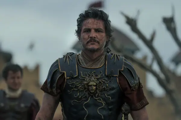 Pedro Pascal plays Marcus Acacius walks in armour across a battlefield in Gladiator II from Paramount Pictures.