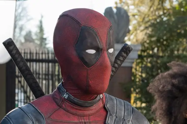 Ryan Reynolds as Wade Wilson in Deadpool and Wolverine with scars on his face, wearing a blue jacket