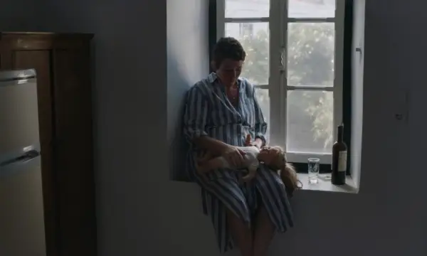 Olivia Colman as Leda holding the doll in The Lost Daughter