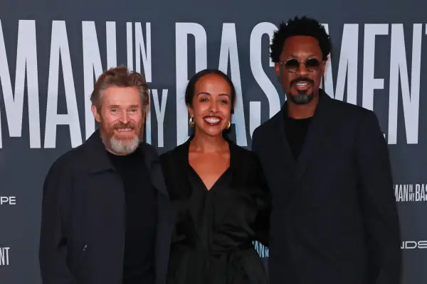 Willem Dafoe, Nadia Latif and Corey Hawkins on the red carpet for The Man in My Basement, all smiling and wearing black.