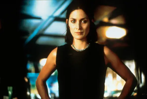 Carrie-Anne Moss as Natalie standing with her hands on her hips in Memento
