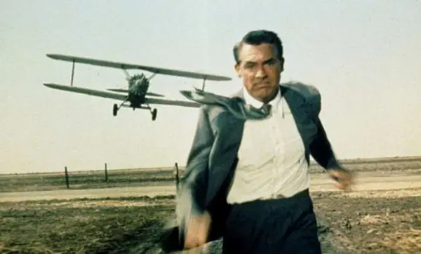 A man in a suit running away from a plane