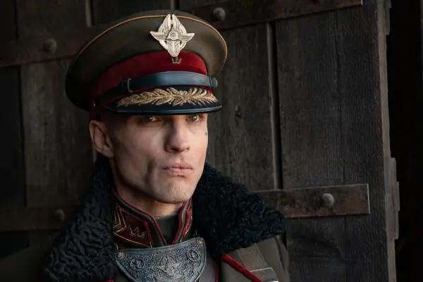 Atticus Noble wears military-style attire and stares menacingly into the distance