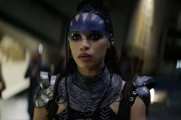 Cleopatra Coleman plays Devra Bloodaxe in Rebel Moon with blue facepaint, wearing battle armour