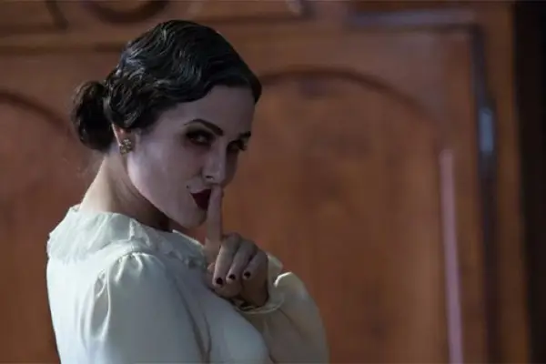 A character in Insidious 2 with her finger to her lips