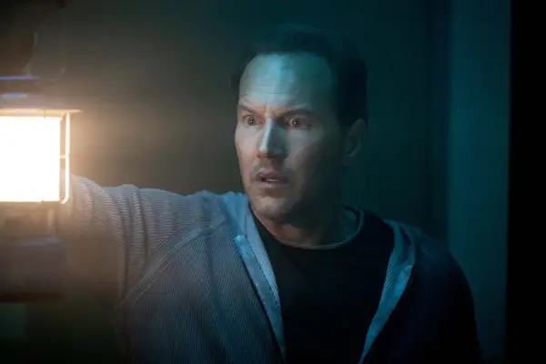 Patrick Wilson stars in Insidious: The Red Door, holding a lamp
